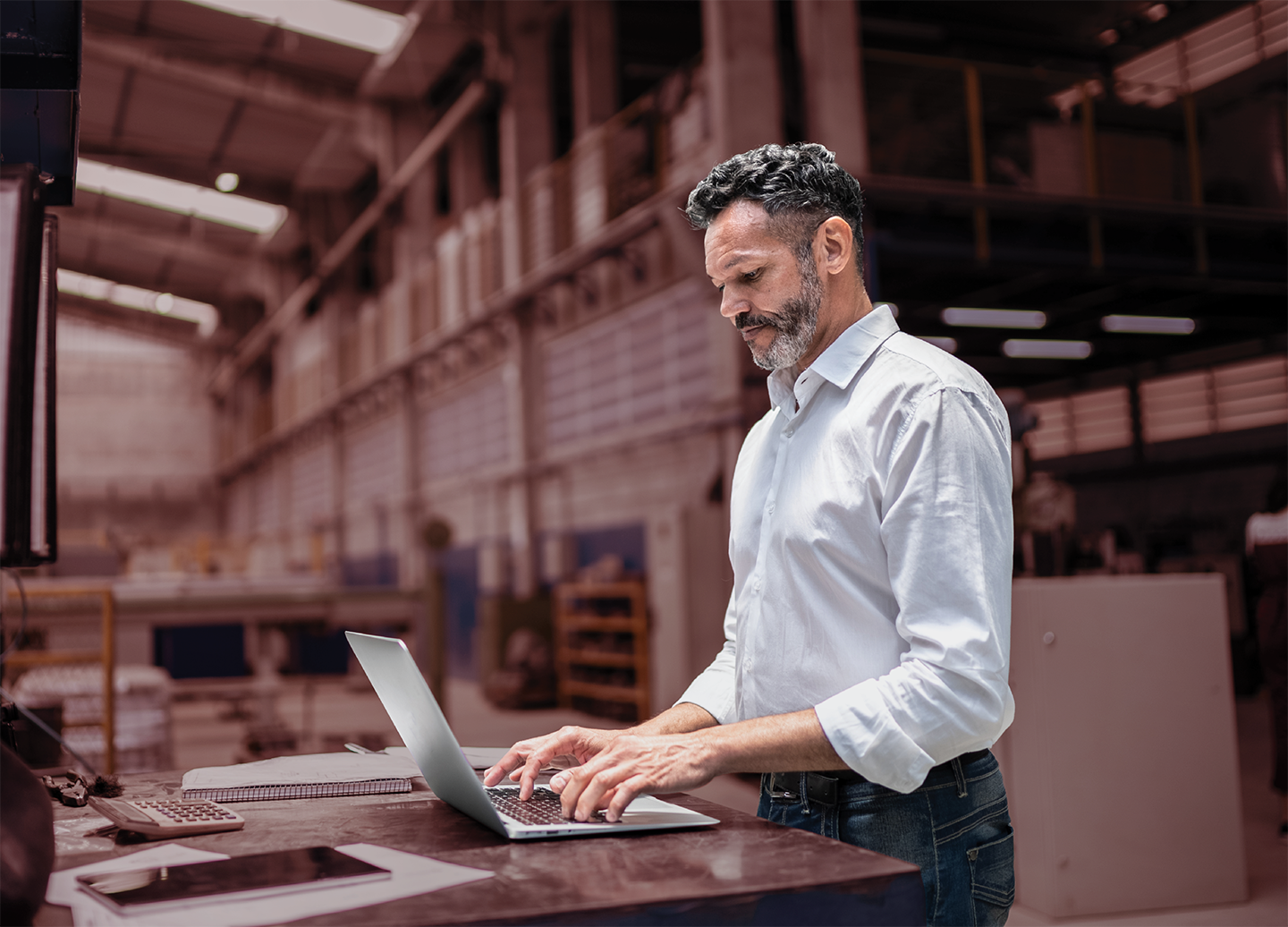 Man on laptop in warehouse
